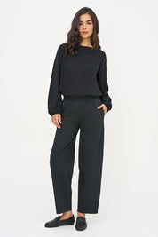 Blouse noire à manches bouffantes portée avec un pantalon noir, vue plein pied
