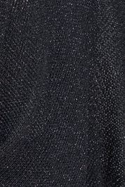 Détail du tricot noir légèrement scintillant du boléro