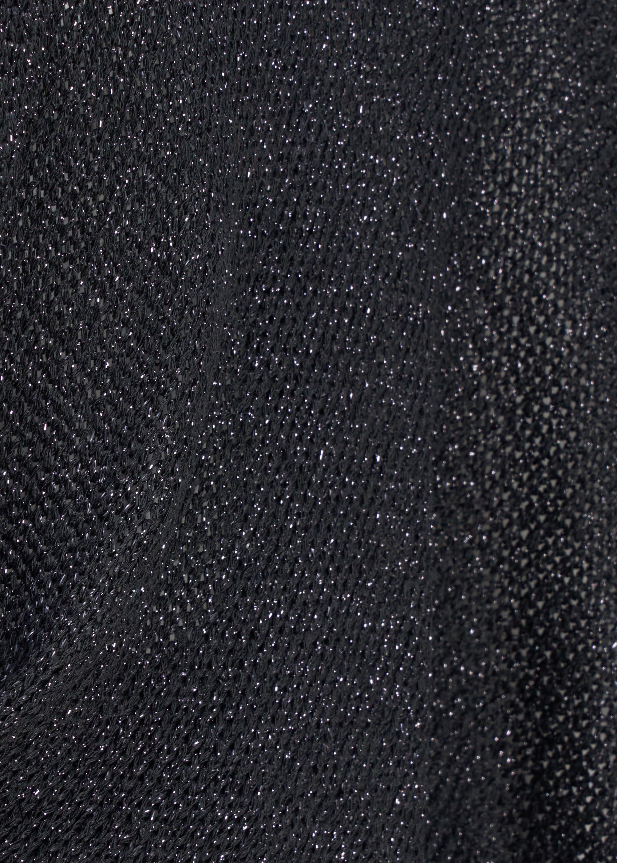 Détail du tricot noir légèrement scintillant du boléro