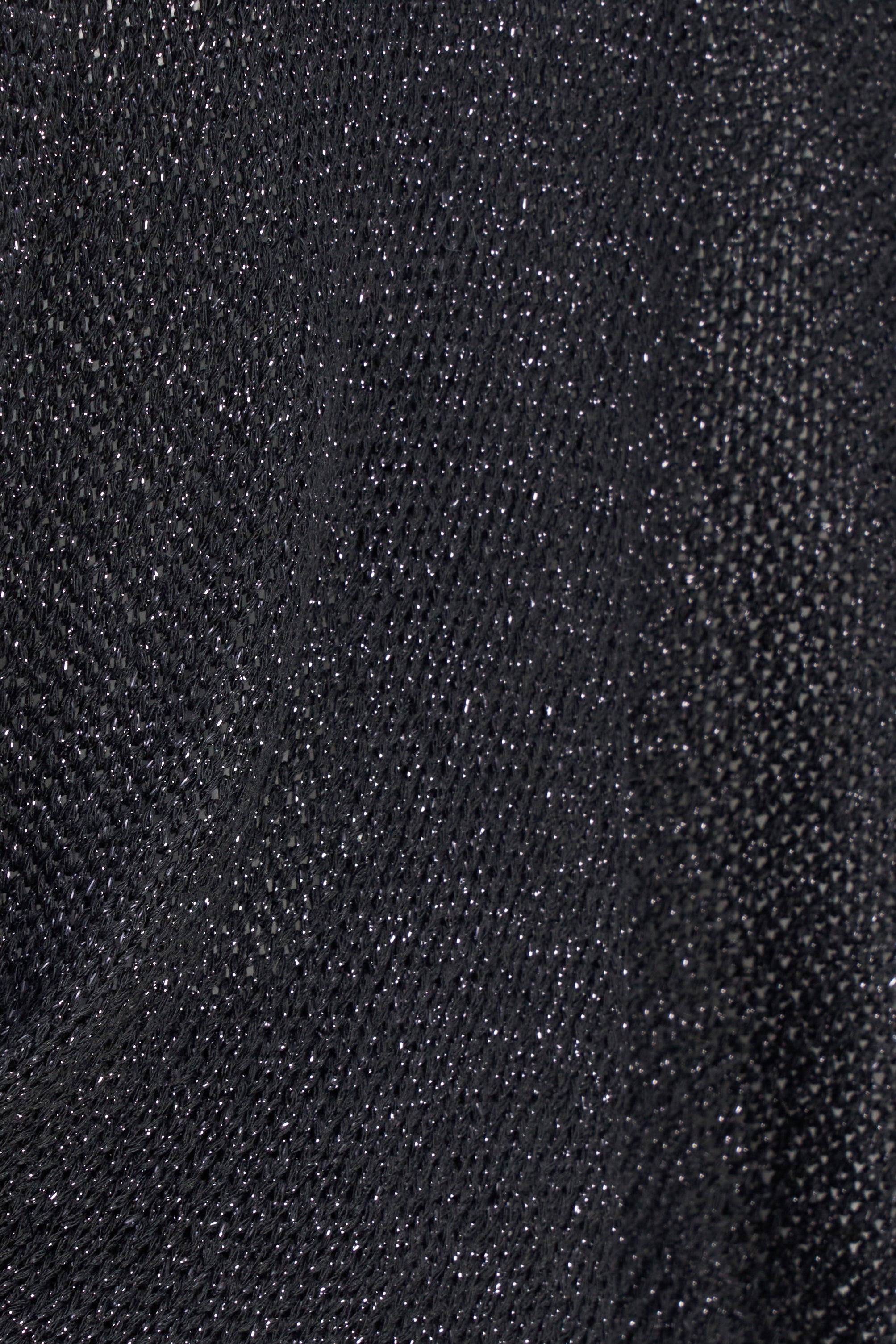 Détail du tricot noir légèrement scintillant du boléro