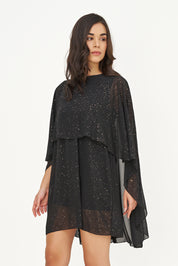 Détail de la robe noire avec poncho fluide à reflets dorés