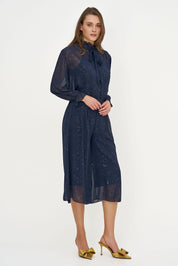 Blouse marine à boucle portée avec une jupe assortie, vue plein pied