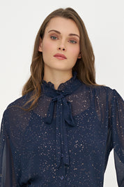 Détail du col volanté et de la boucle de la blouse marine