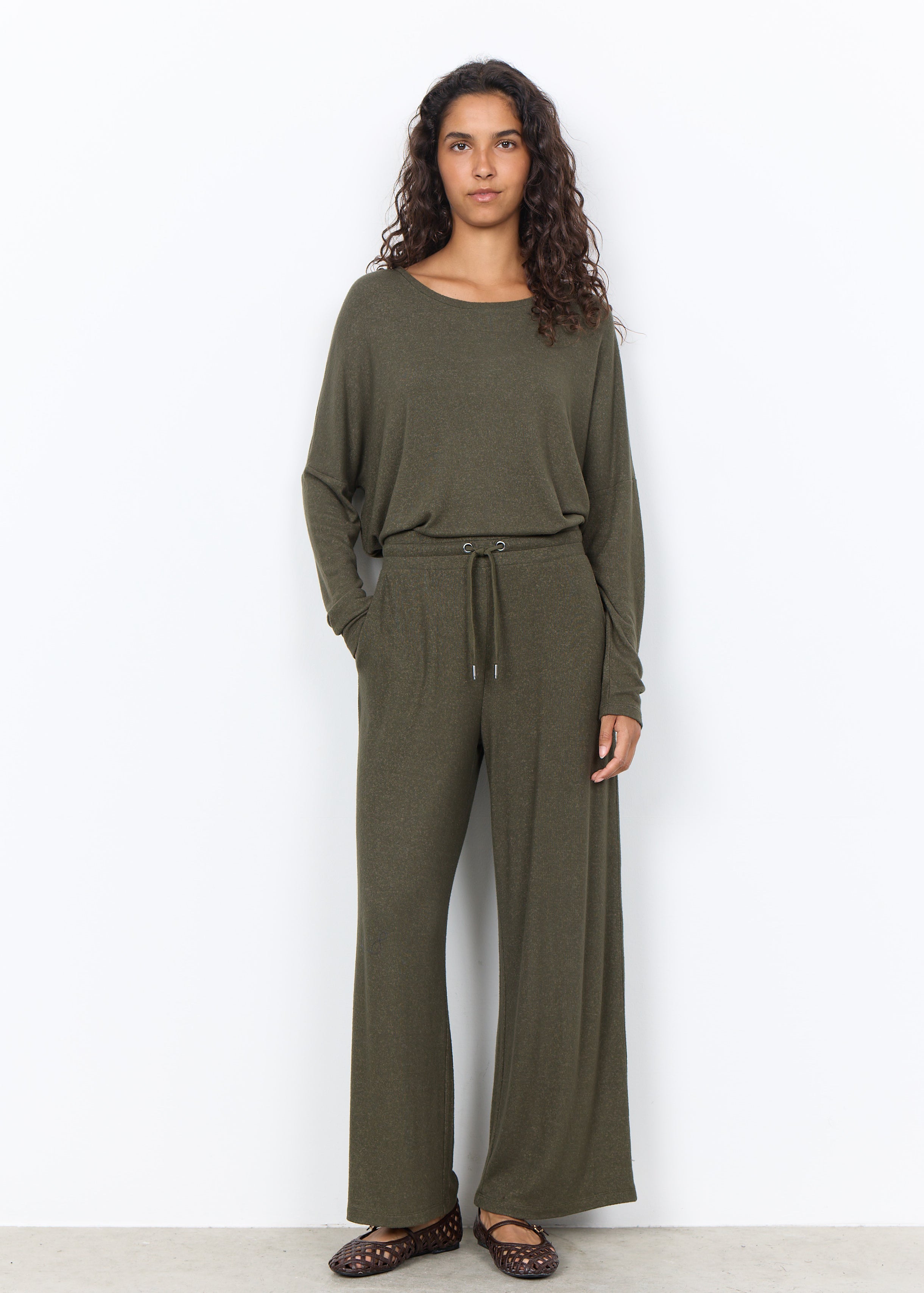 Chandail vert forêt porté avec un pantalon large assorti