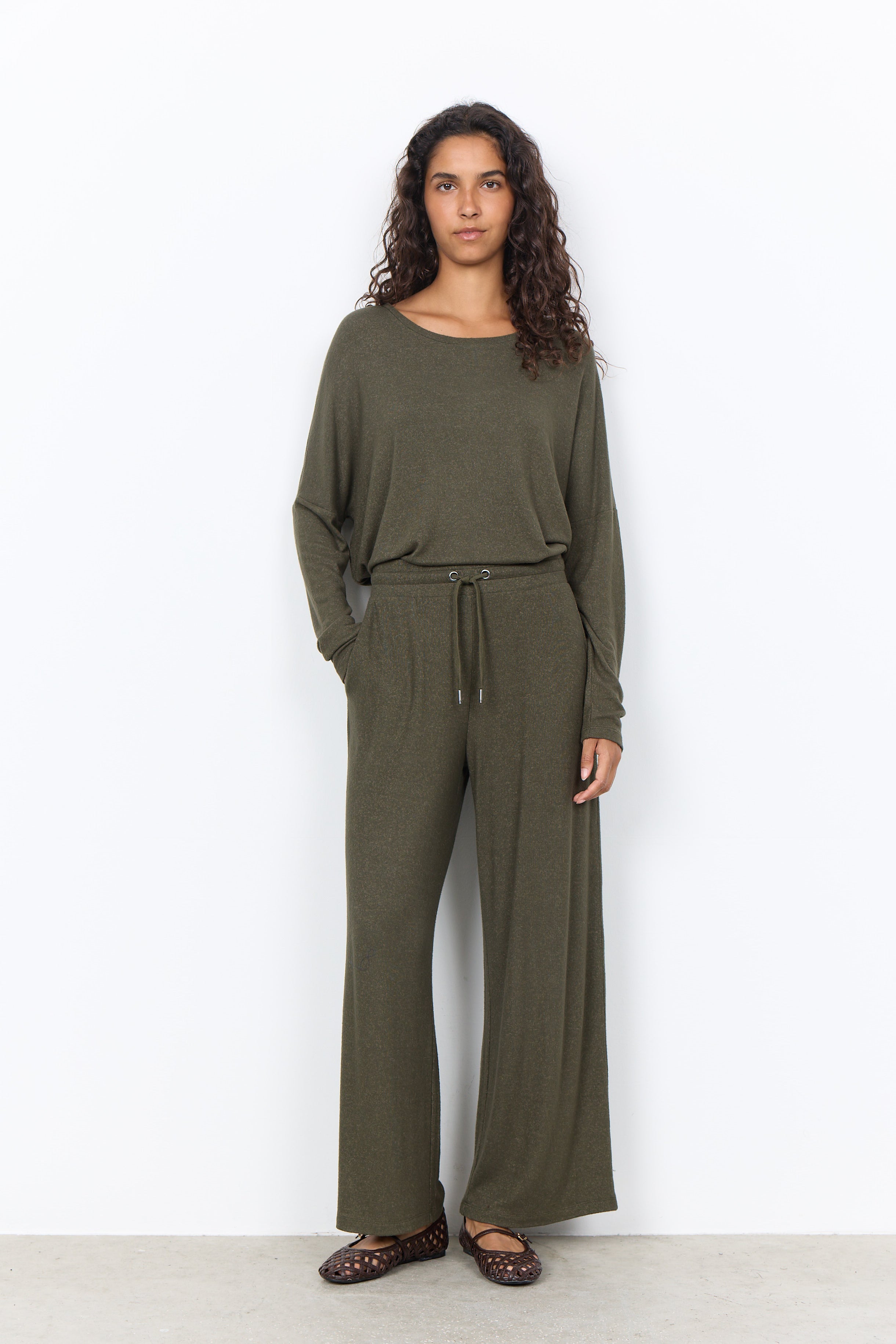 Chandail vert forêt porté avec un pantalon large assorti