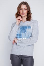 Chandail Cyc Coco Y Club en tricot fin gris, avec un capuchon, des motifs carrés bleu et argent, et des manches longues.