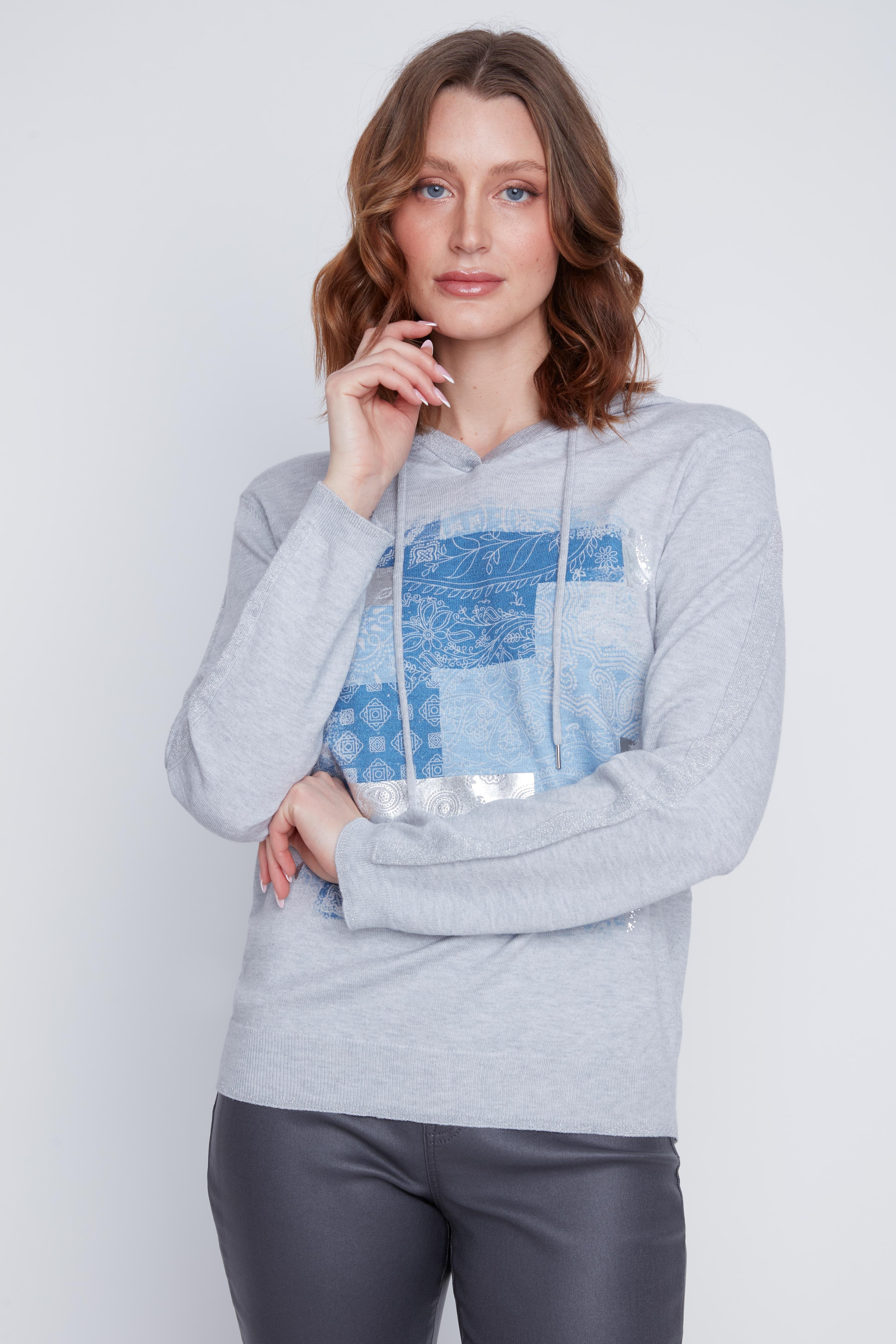 Chandail Cyc Coco Y Club en tricot fin gris, avec un capuchon, des motifs carrés bleu et argent, et des manches longues.