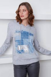 Chandail Cyc Coco Y Club en tricot fin gris, avec un capuchon, des motifs carrés bleu et argent, et des manches longues.