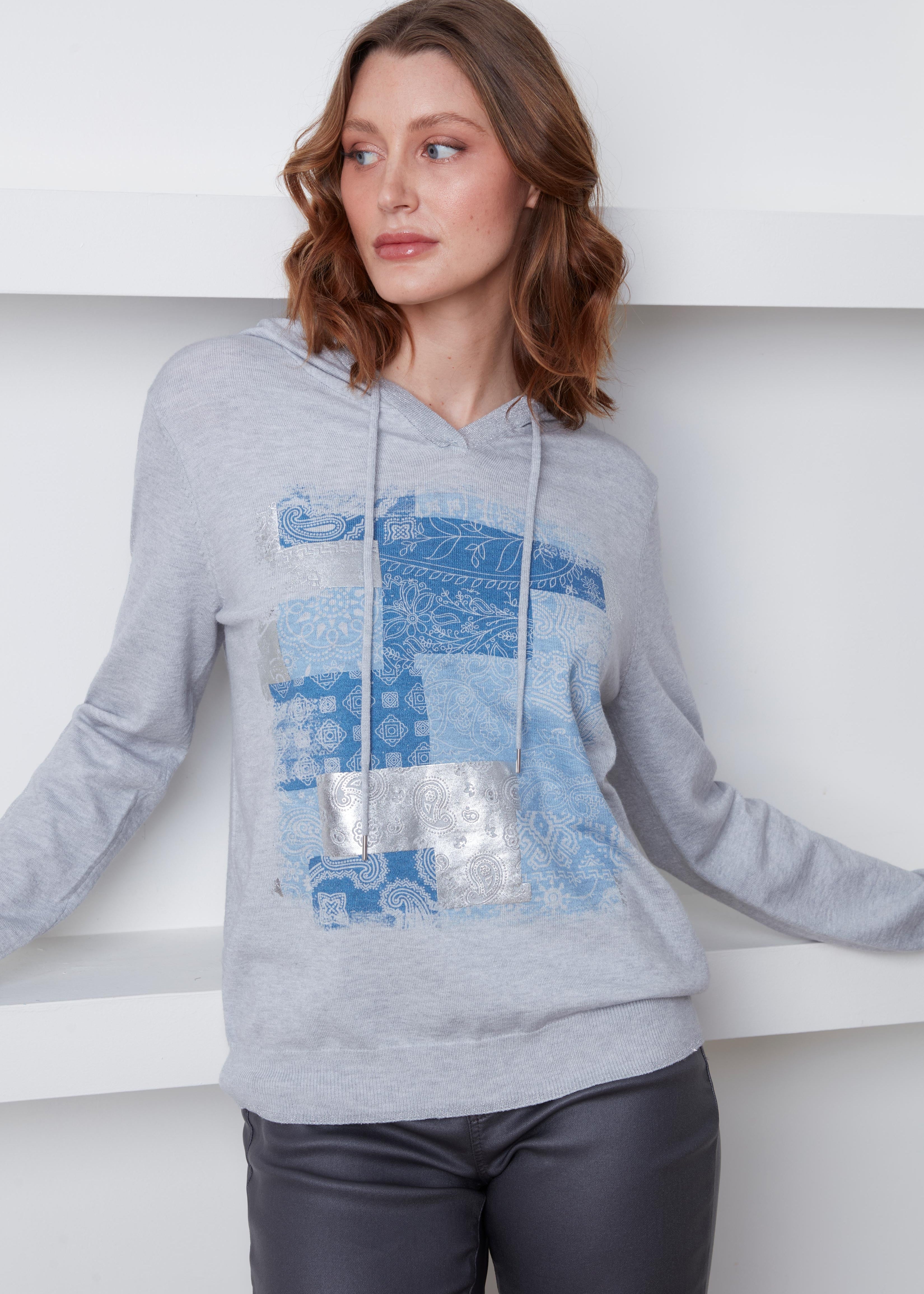 Chandail Cyc Coco Y Club en tricot fin gris, avec un capuchon, des motifs carrés bleu et argent, et des manches longues.