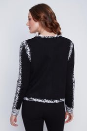 Cardigan Cyc en tricot noir et blanc avec un effet pixelisé, un col rond et une fermeture éclair.