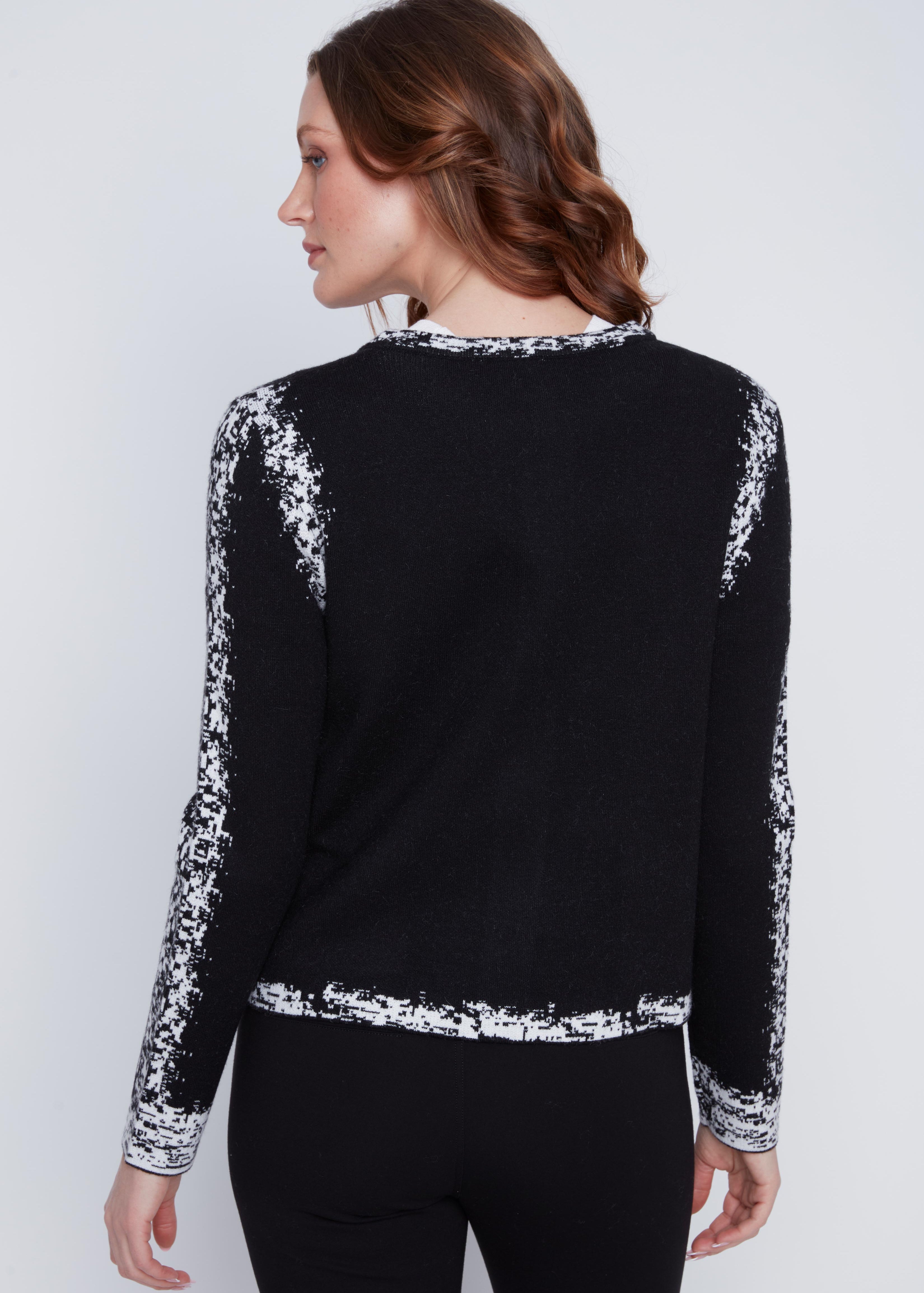 Cardigan Cyc en tricot noir et blanc avec un effet pixelisé, un col rond et une fermeture éclair.