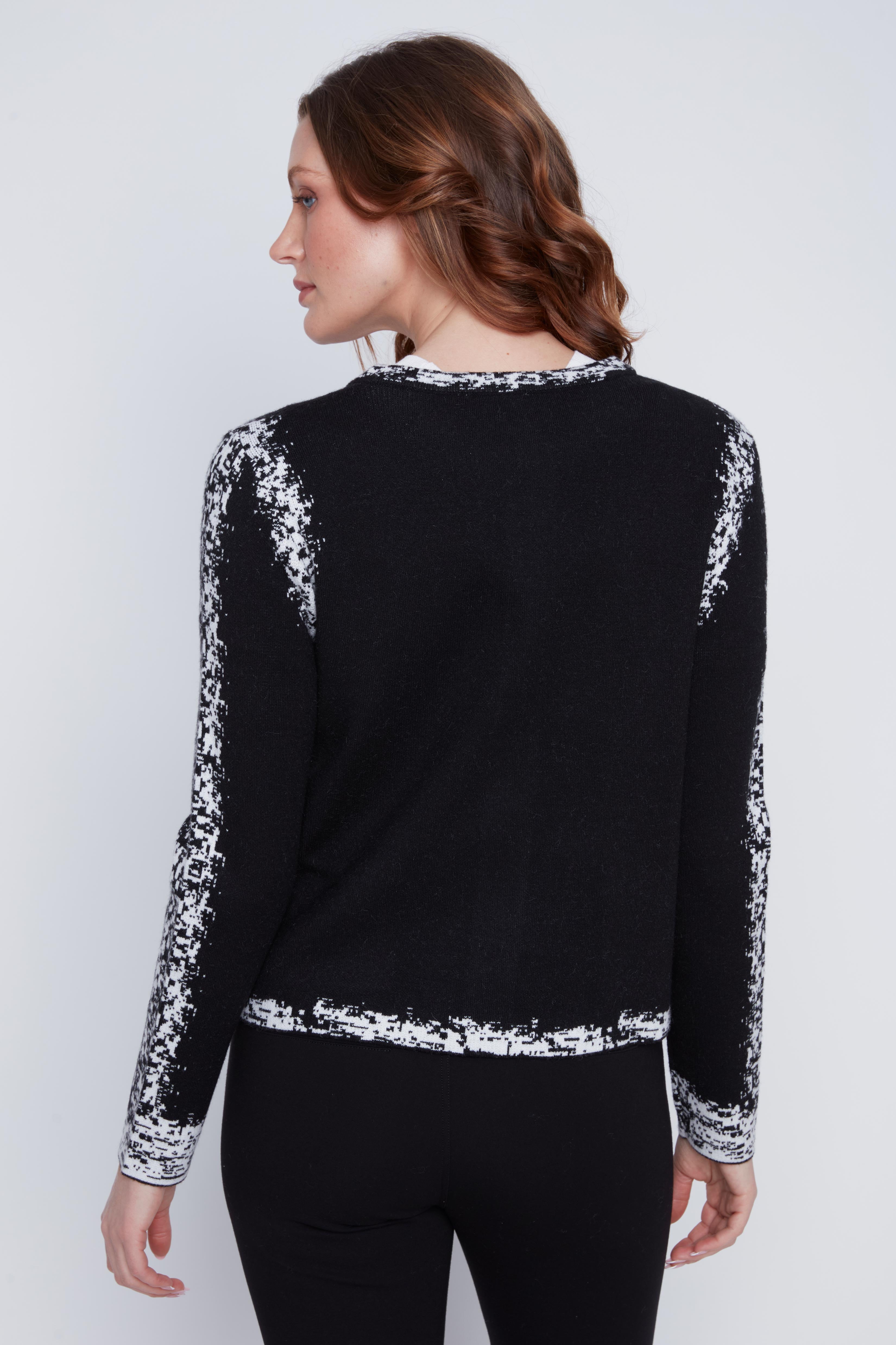 Cardigan Cyc en tricot noir et blanc avec un effet pixelisé, un col rond et une fermeture éclair.
