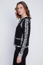 Cardigan Cyc en tricot noir et blanc avec un effet pixelisé, un col rond et une fermeture éclair.