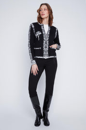 Cardigan Cyc en tricot noir et blanc avec un effet pixelisé, un col rond et une fermeture éclair.