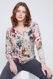 Chandail Cyc Coco Y Club en tricot léger, imprimé de fleurs vertes, rouges et ocre sur fond beige, avec un col en V.