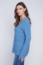 Chandail Cyc en tricot texturé de couleur bleu acier, avec un col en V et deux poches à l'avant pour se réchauffer les mains.