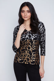 Chandail léger à manches longues pour femme, col en V, avec un imprimé argenté et doré. Tissu extensible 61% polyester, 35% viscose, 4% élasthanne. Marque Coco Y Club.