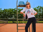 Chandail blanc à manches 3/4 avec col rond, imprimé artistique de femme avec touches de rouge et de marine et détails de strass, manches ajustables.