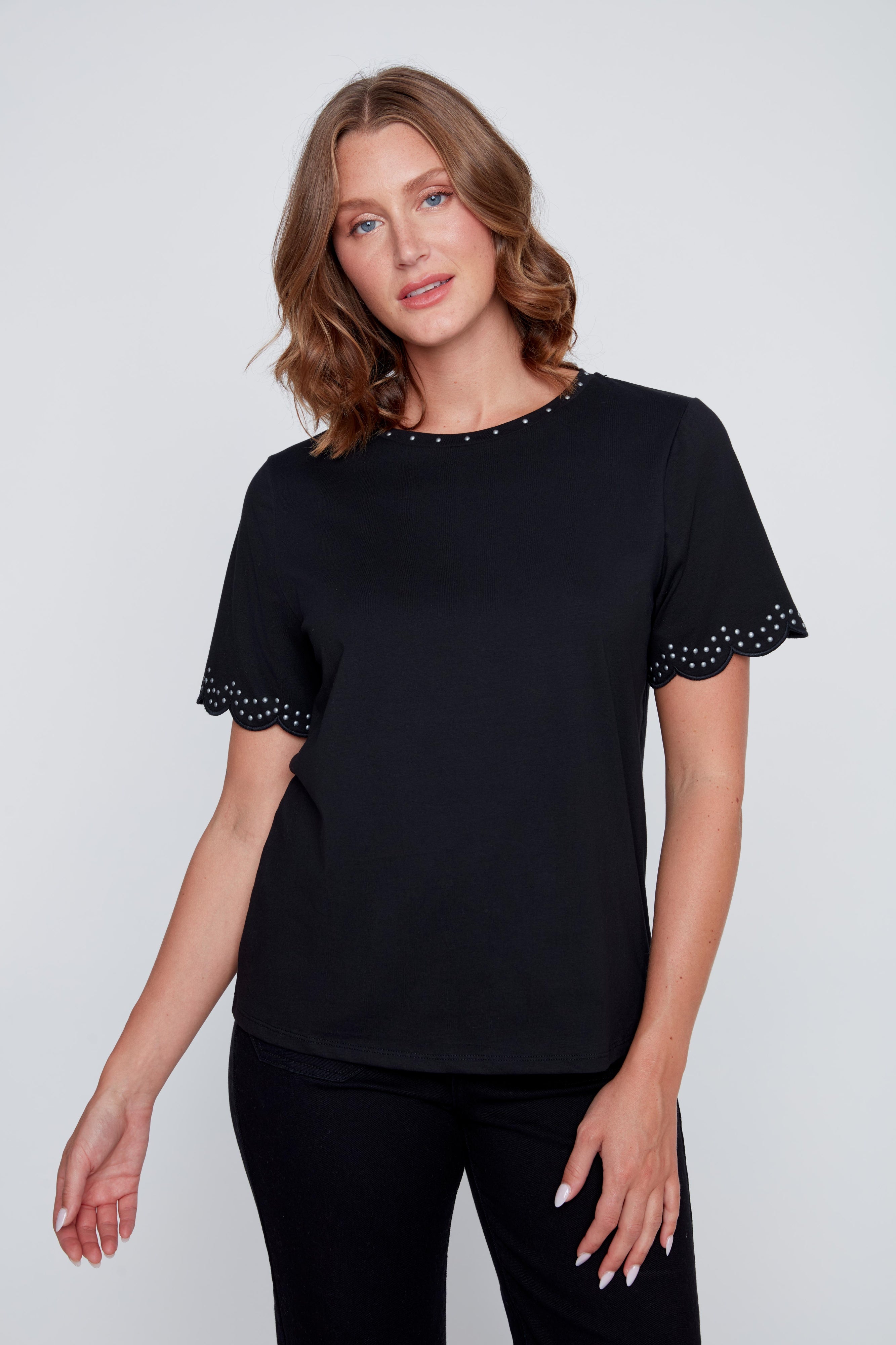 T-shirt col rond avec studs argentés au col et aux manches, finition arrondie féminine aux manches, offert en ivoire et en noir.