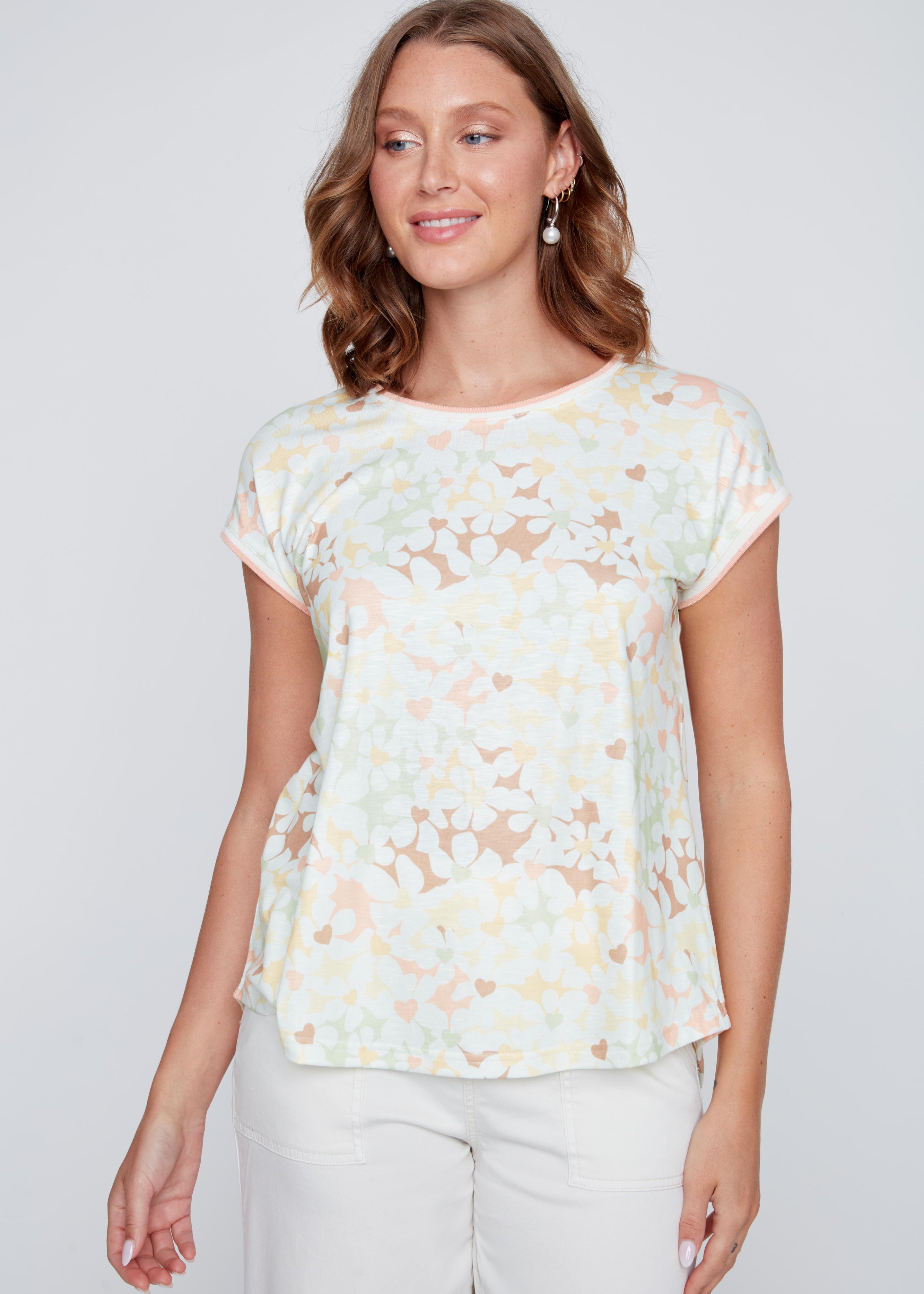 T-shirt crème à col rond avec imprimé de fleurs délicates et de cœurs pastel, tissu léger en polyester et élasthanne.