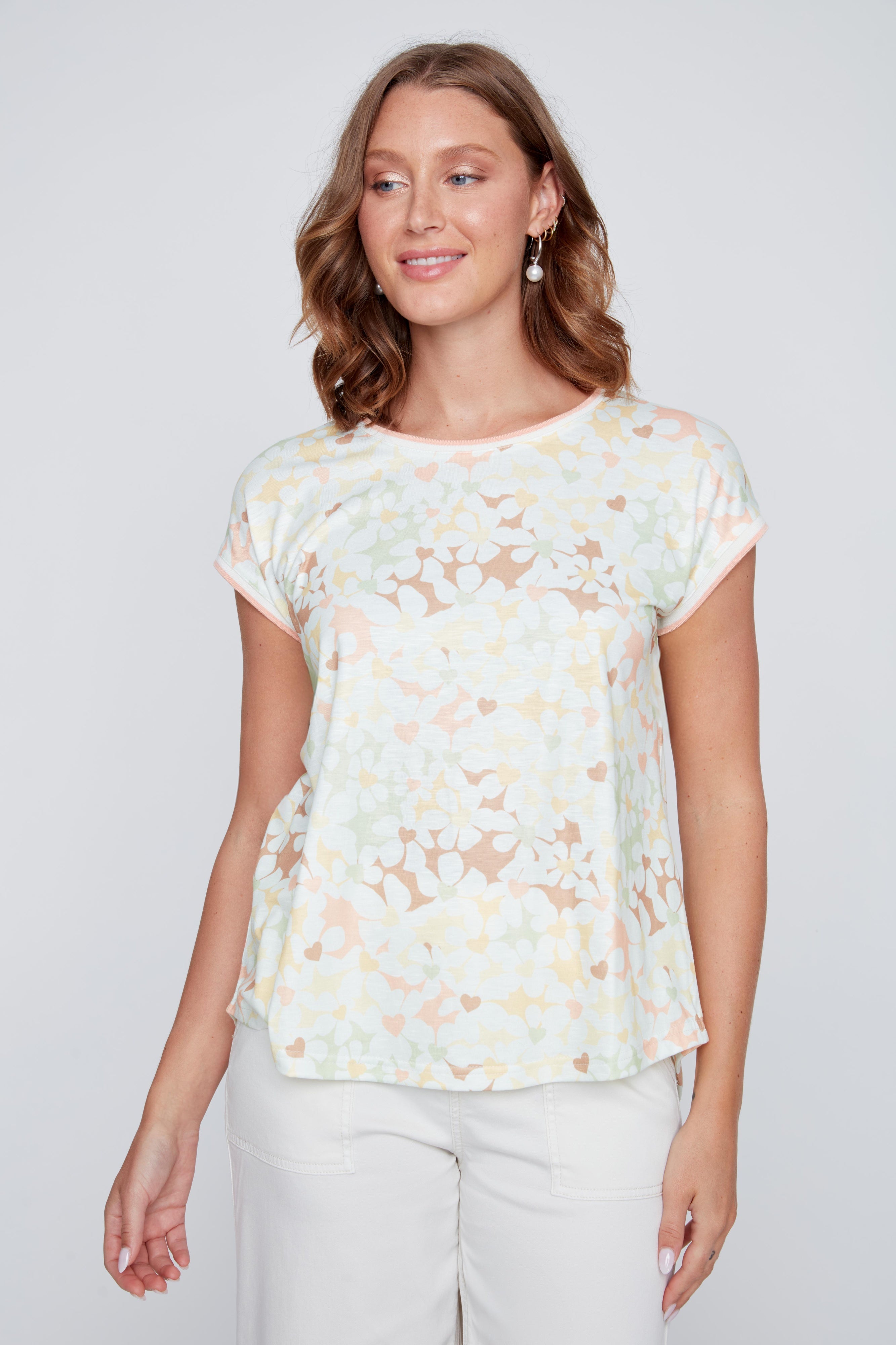 T-shirt crème à col rond avec imprimé de fleurs délicates et de cœurs pastel, tissu léger en polyester et élasthanne.