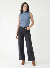 Jean noir à jambe large CYC avec motifs floraux ton sur ton porté par une femme