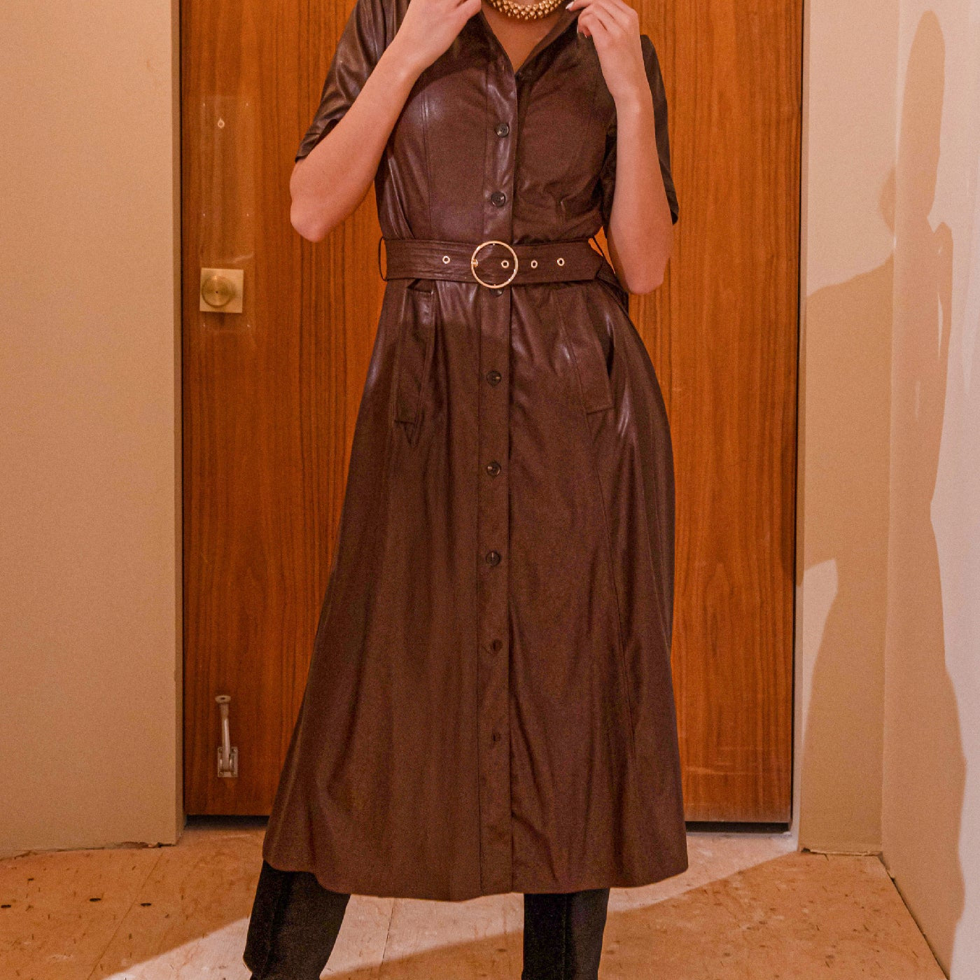 Robe chemise en cuir végane acajou, avec une ceinture à la taille et des boutons sur le devant.
