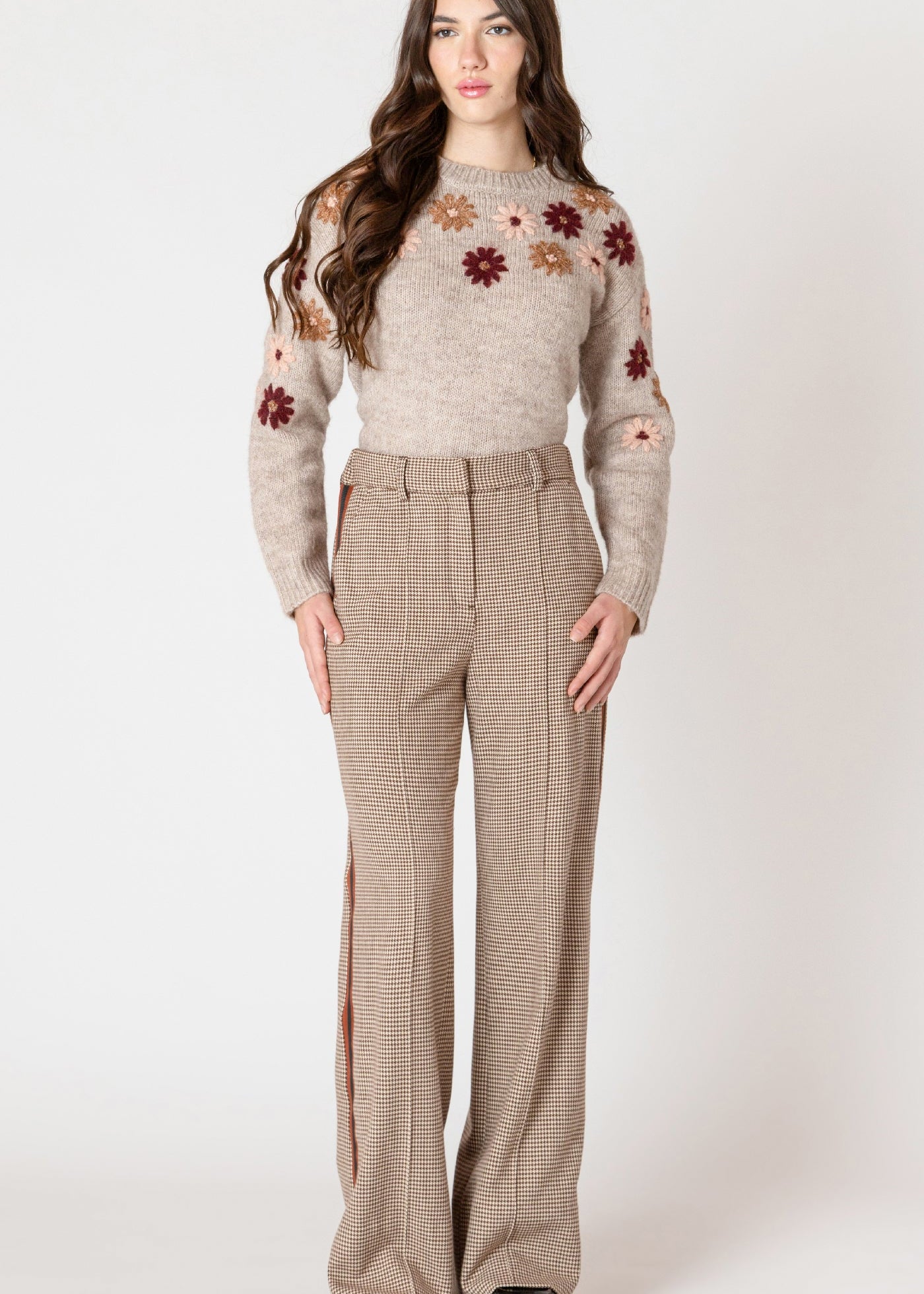 Pantalon en tricot extensible Black Tape, motif micro pied de poule brun et beige, avec une bande rouge et noire sur la jambe.