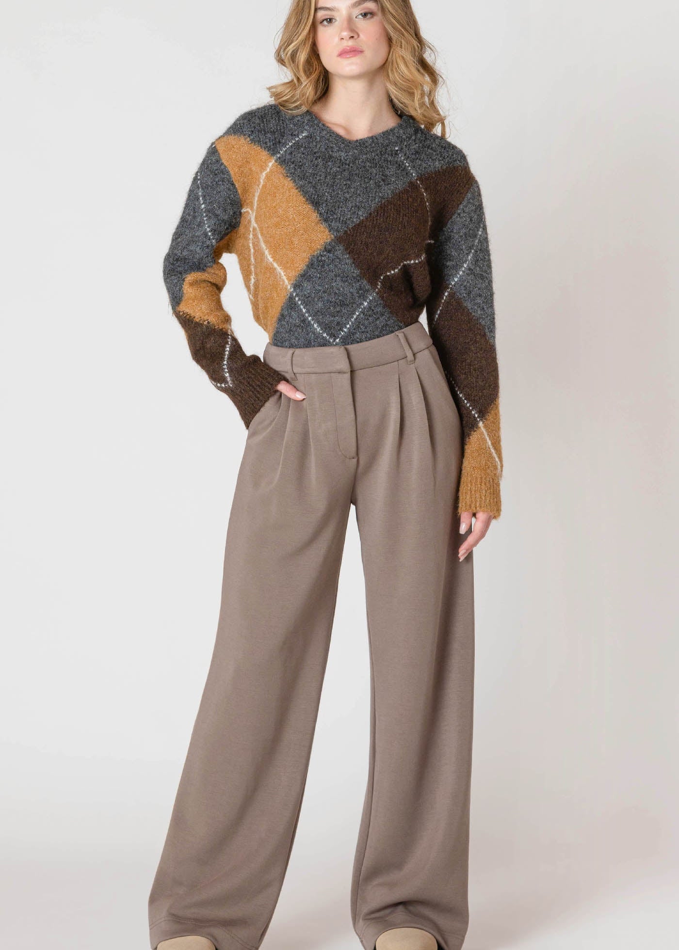 "Pantalon taille haute, coupe ample et jambe large, de couleur taupe foncée. Muni de plis sur le devant et fabriqué dans un mélange doux de rayonne et de polyester pour un tombé fluide. Marque Room 34."