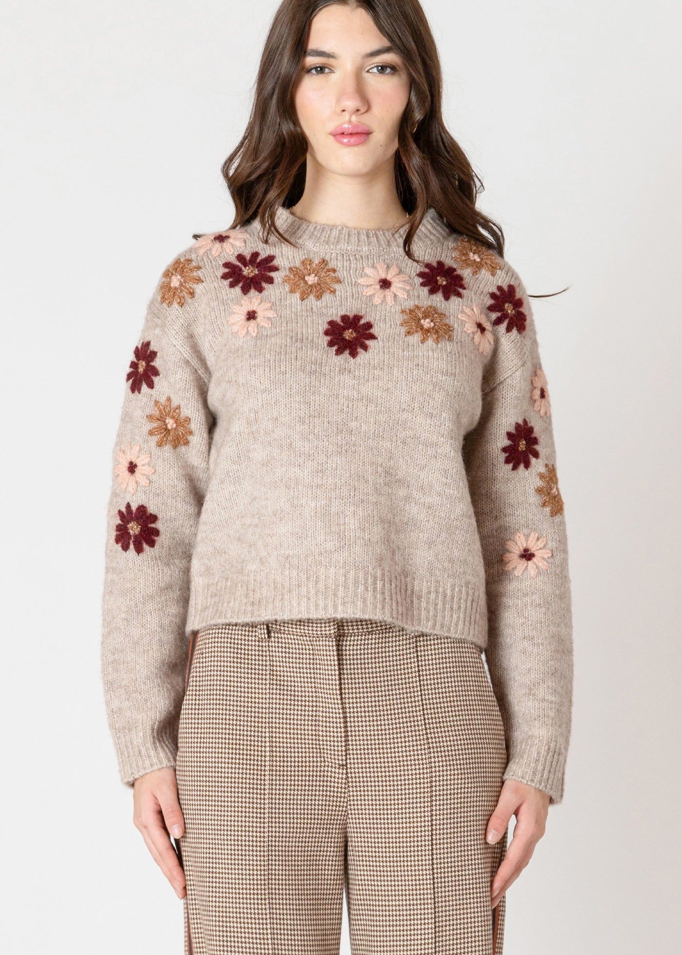 "Chandail en tricot à col rond, de couleur unie (pré floral). Orné de motifs de fleurs brodées sur le devant. Composition majoritaire en polyester recyclé, avec de la laine et du spandex. Marque Black Tape."