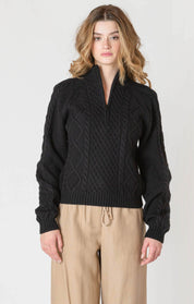 "Chandail en tricot noir uni, doté d'un col montant et d'une demi-fermeture éclair sur le devant. Matière 100% polyester pour une bonne tenue. Marque Room 34."