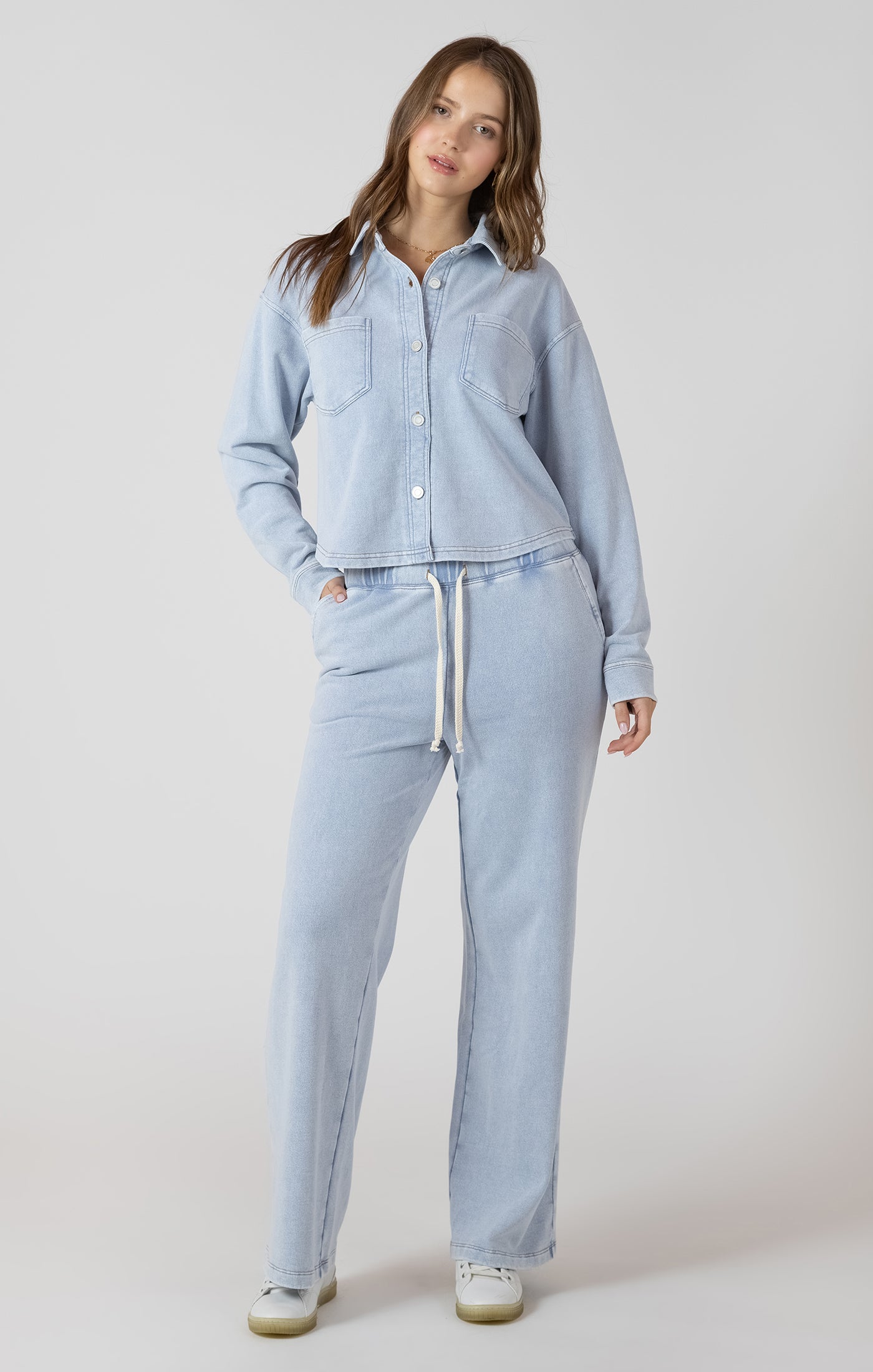 Pantalon jogging large effet jeans, couleur bleu clair lavé, tissu en coton et polyester, coupe ample et confortable.