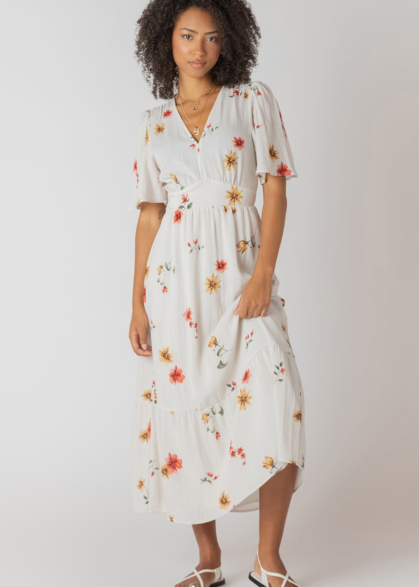 Robe longue à imprimé floral multicolore, col en V et dos nu, tissu souple en polyester et élasthanne, style féminin et léger.