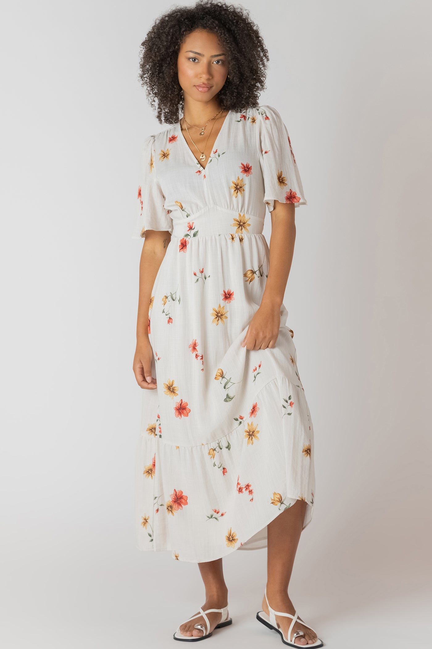 Robe longue à imprimé floral multicolore, col en V et dos nu, tissu souple en polyester et élasthanne, style féminin et léger.