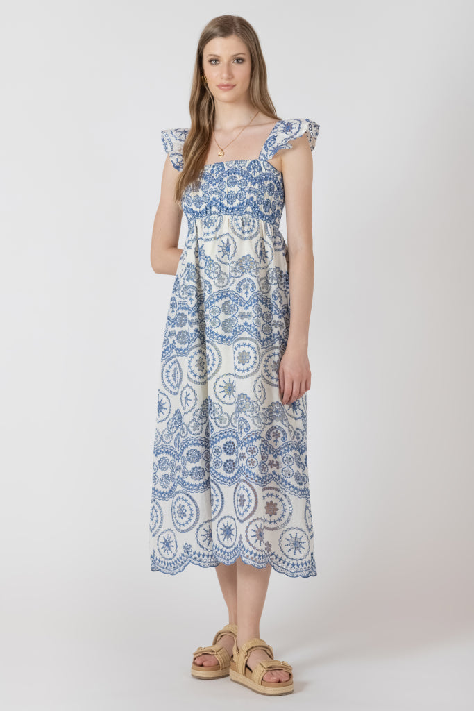 Robe longue bleu et crème avec détails de broderie, silhouette fluide et style féminin élégant.