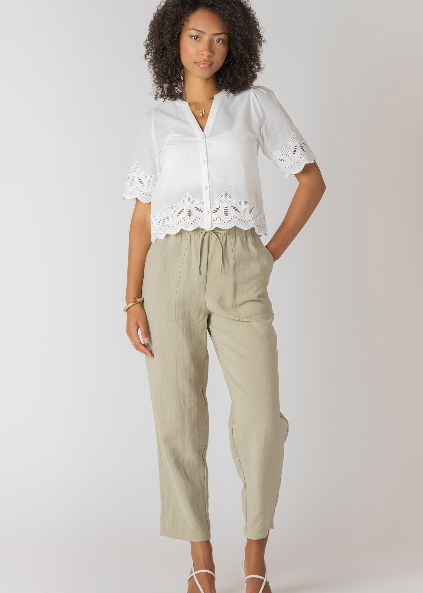 Pantalon droit à taille élastique avec poches, couleur sauge claire, tissu fluide en viscose et polyester, style confortable et pratique.