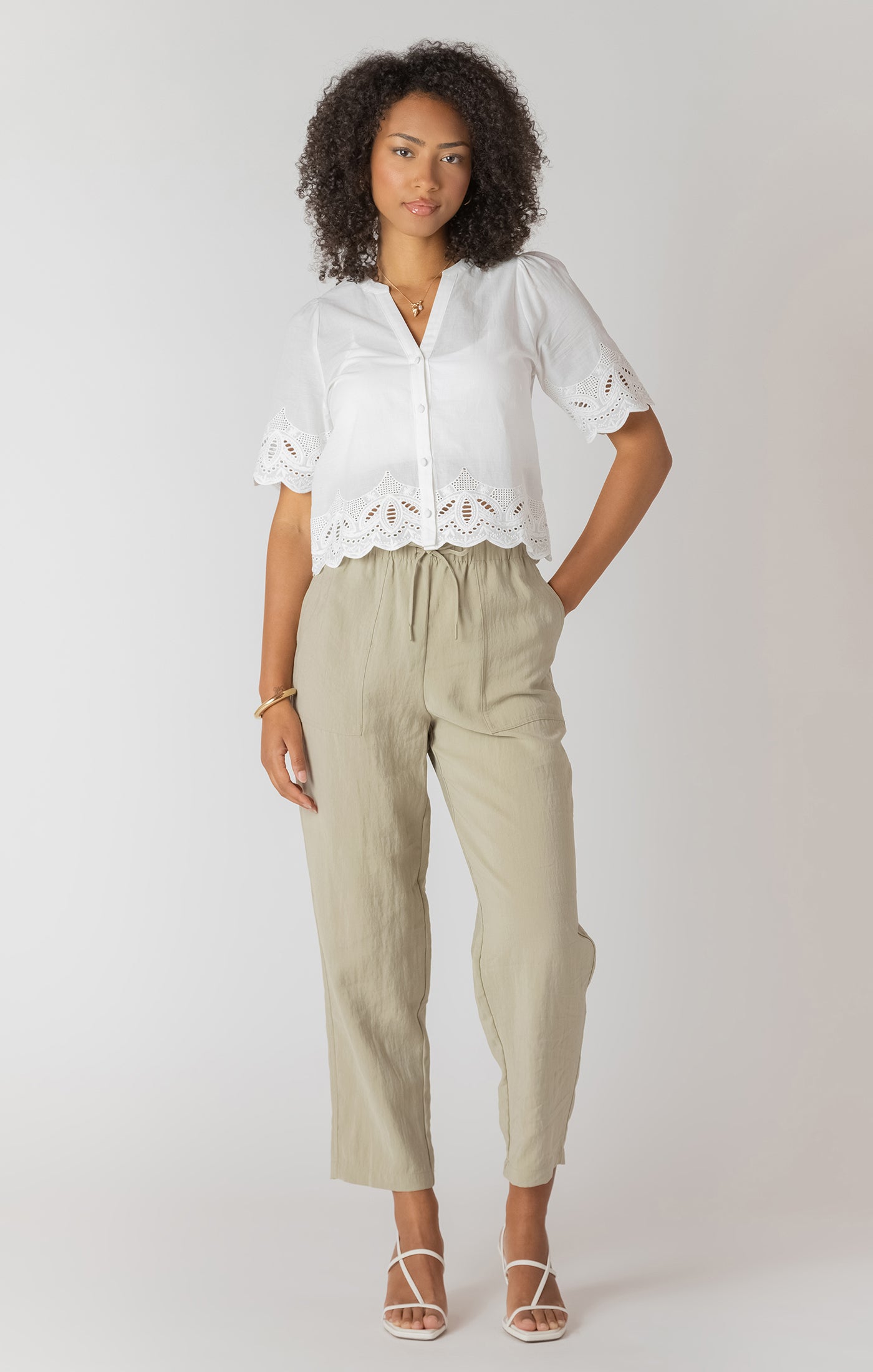 Pantalon droit à taille élastique avec poches, couleur sauge claire, tissu fluide en viscose et polyester, style confortable et pratique.