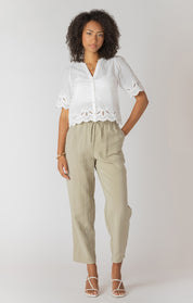 Pantalon droit à taille élastique avec poches, couleur sauge claire, tissu fluide en viscose et polyester, style confortable et pratique.