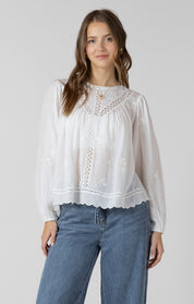 Blouse avec broderies de fleurs et détails de dentelle, manches avec élastique, style féminin et estival.
