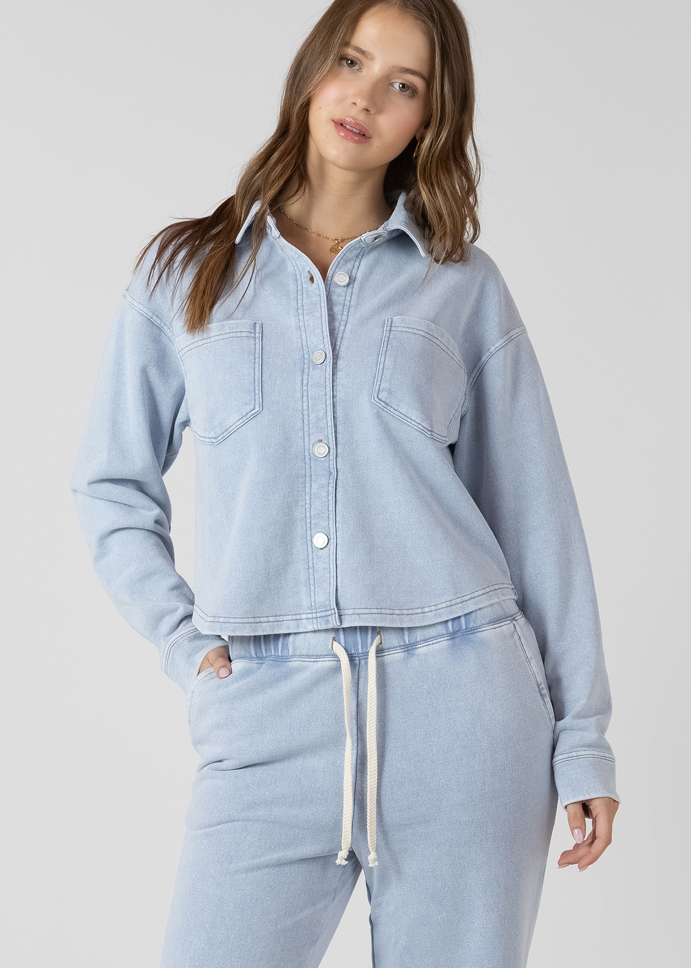 Chemisier en jogging effet jeans, couleur bleu clair lavé, tissu en coton et polyester, style décontracté et confortable.