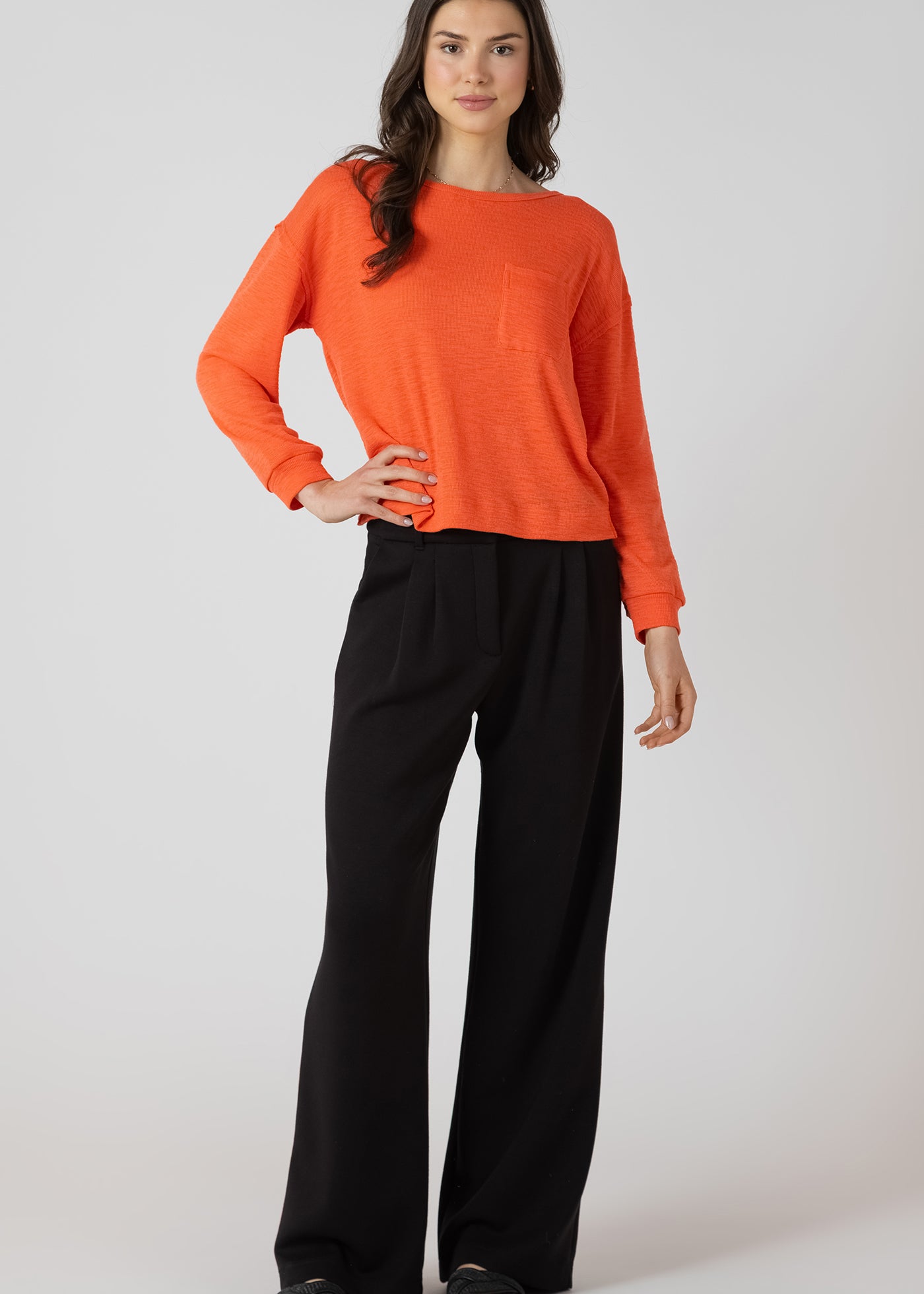 Chandail oversize avec poche à l’avant, couleur éclat d’orange, tissu en polyester, coton et viscose, style décontracté et confortable.