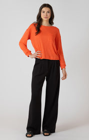 Chandail oversize avec poche à l’avant, couleur éclat d’orange, tissu en polyester, coton et viscose, style décontracté et confortable.