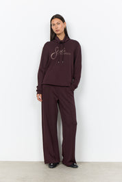 Chandail prune à col montant porté avec un pantalon large assorti