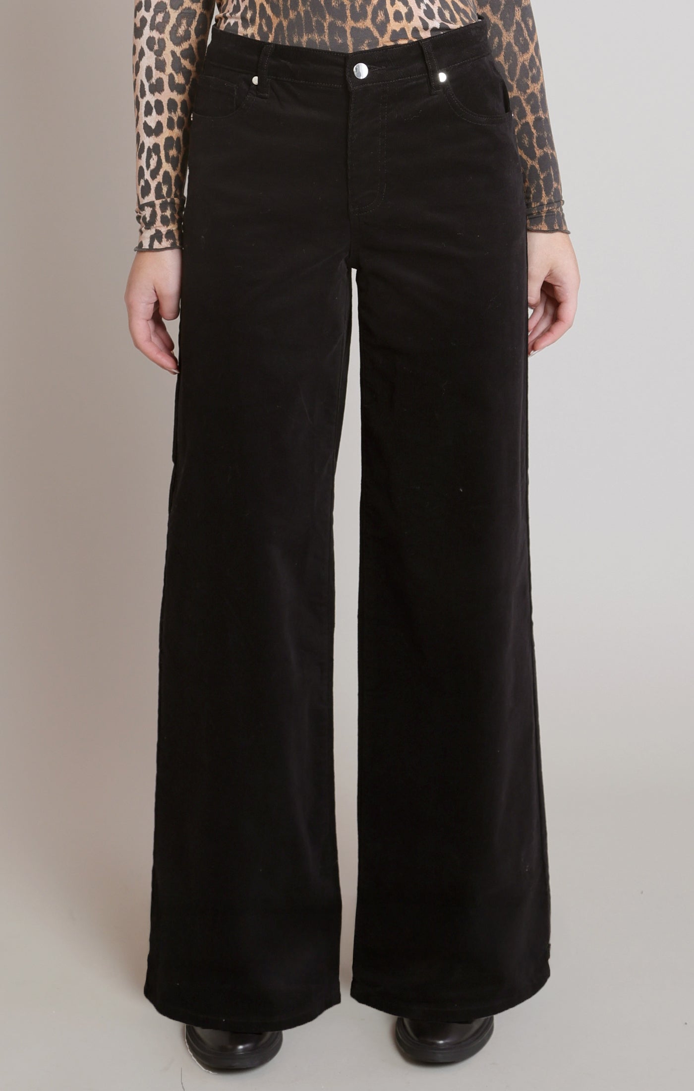 Détail du pantalon noir en velours côtelé à jambe large