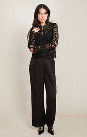 Blouse noire en crochet ajouré portée avec un pantalon noir, silhouette complète