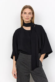 Blouse noire à col foulard portée de face.