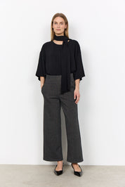 Vue portée de la blouse noire à manches amples.