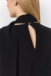 Vue portée de dos de la blouse noire à manches amples.