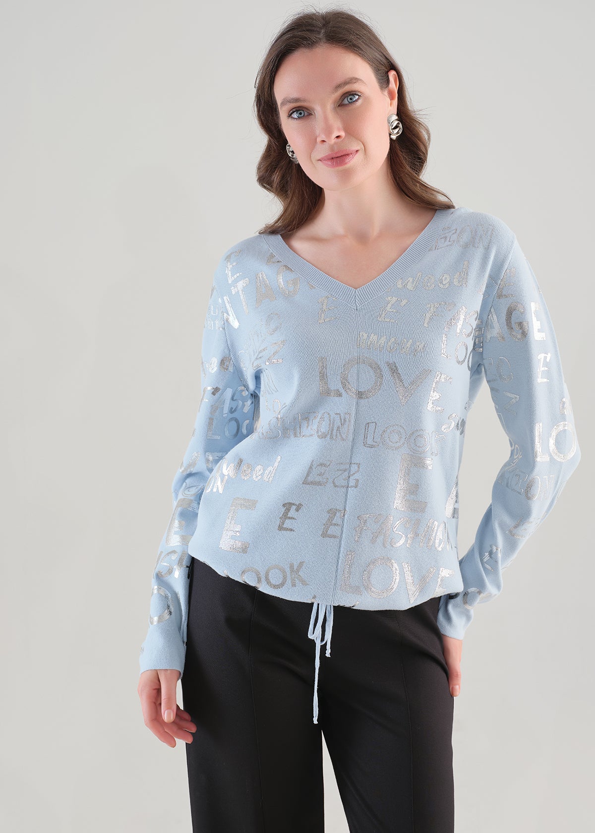 Chandail bleu Tricotto 96111 à col V avec motif lettré argenté et cordon ajustable, vue rapprochée