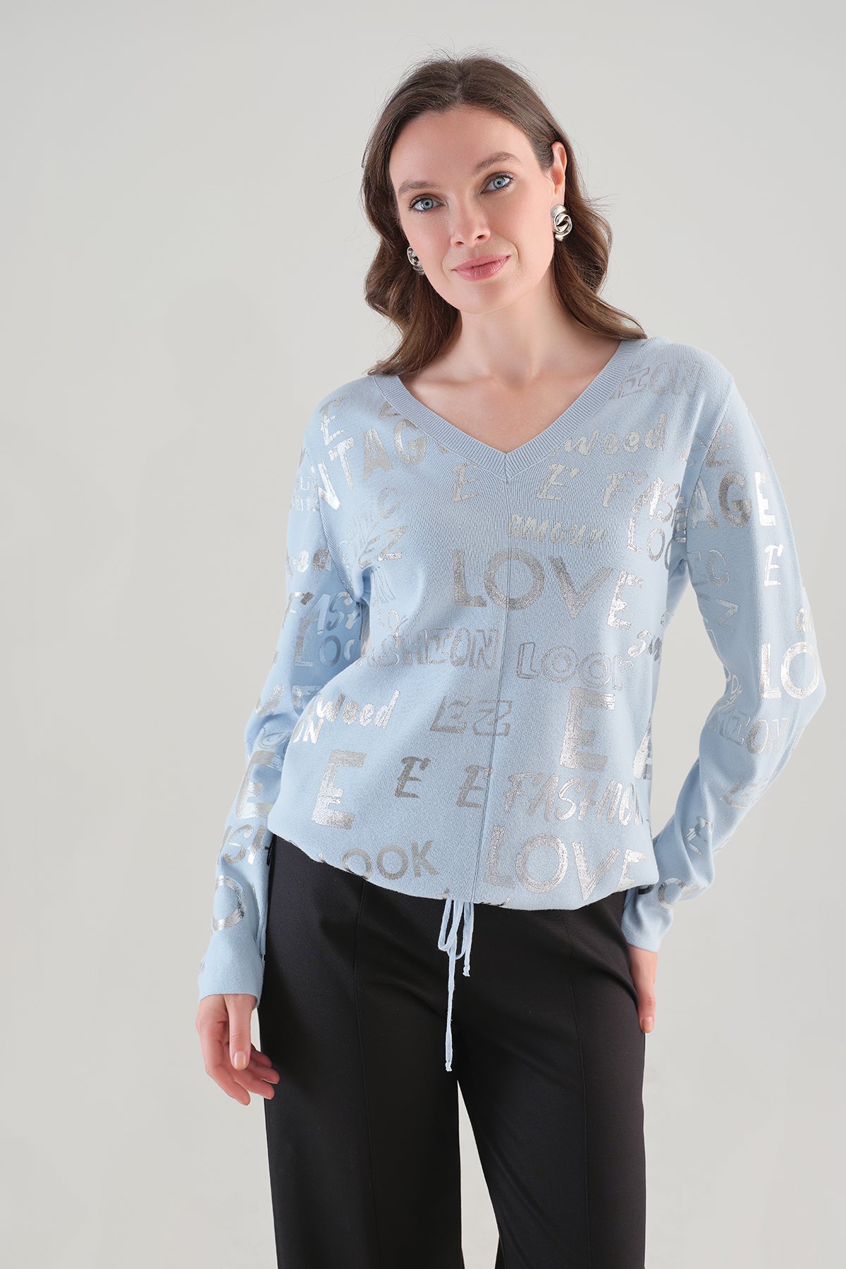 Chandail bleu Tricotto 96111 à col V avec motif lettré argenté et cordon ajustable, vue rapprochée
